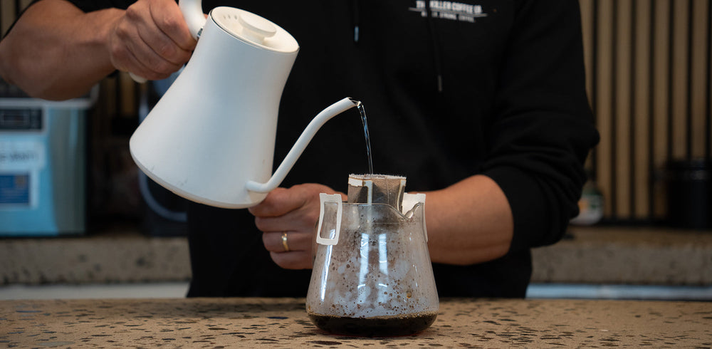 Rip 'n Drip coffee bag hanging on a mug with water being poured over